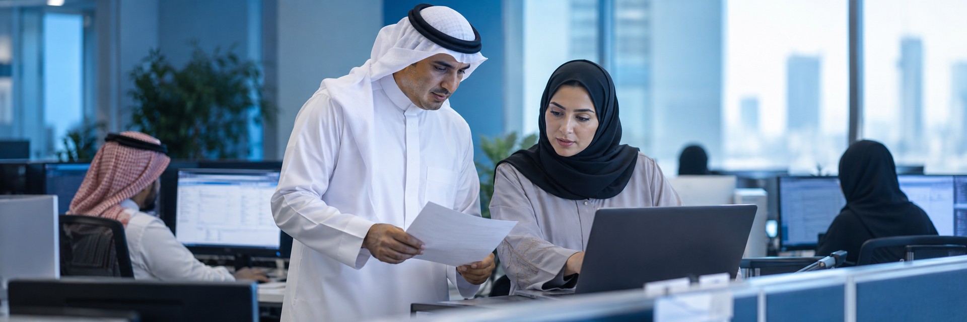 Saudi colleagues reviewing a tablet during a technology discussion